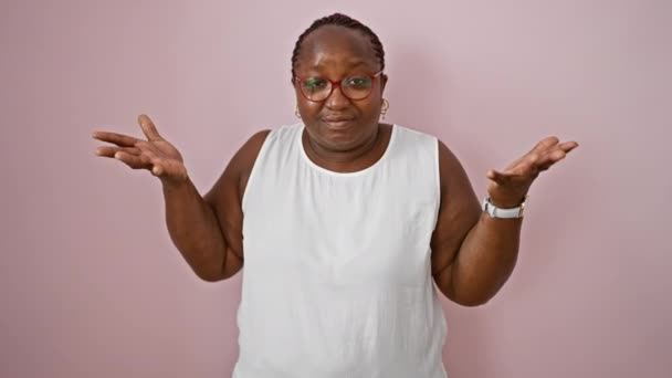 Mujer Afroamericana Despistada Pie Sobre Fondo Rosa Aislado Expresión Incierta — Vídeo de stock