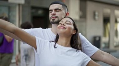 Güzel bir çift bir arada duruyor, kolları açık, güvenli bir şekilde şehirde nefes alıyorlar, güneşli bir sokakta aşklarının tadını çıkarıyorlar..