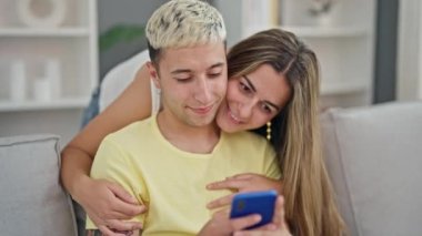 Güzel bir çift evde akıllı telefon kullanıyor.