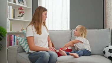 Beyaz anne ve küçük kız evlerinin rahat oturma odasında birbirlerine doğum günü hediyeleriyle sürpriz yapıyorlar. İki kuşak özel bir anı kutluyor..