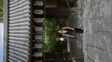 Neşeli, güzel İspanyol kadın, gururla poz veriyor gözlükleriyle, Kyoto 'nun dingin kodaiji tapınağında muhteşem bir gülümseme sergiliyor.