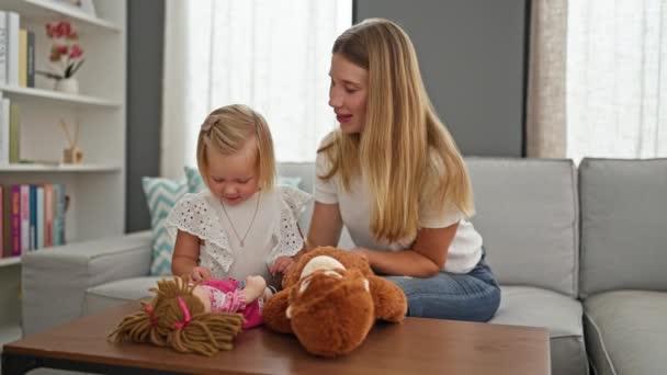 コーカサス人の母親と娘は喜んで自宅でリラックスした瞬間を楽しんで おもちゃに囲まれて屋内で快適に座っている間遊び心のあるキスをする — ストック動画