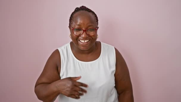 快乐的非洲裔美国女人笑得不可开交 自信地站在一个孤立的粉色背景上 激发出积极和欢乐 — 图库视频影像