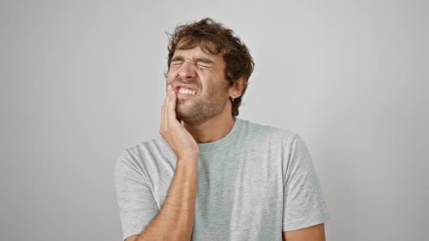 歯痛や歯の病気のために痛みを伴う表情で手で触れるTシャツを着ている若い男性 隔離された白い背景上の歯科医 — ストック動画