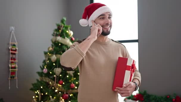 Jovem Árabe Homem Falando Smartphone Segurando Presente Pela Árvore Natal — Vídeo de Stock