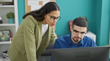 İki ofis çalışanı, bir erkek ve bir kadın, zarif bir toplantı odasının kapalı, profesyonel ortamında birlikte otururken bilgisayardaki iş başarısını beşlikle kutluyor..