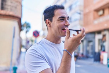 Genç İspanyol adam gülümsüyor. Kendine güveniyor. Sokakta akıllı telefondan konuşuyor.