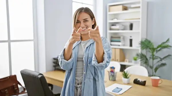 魅力的な若いブロンドの女性は自信を持って仕事で微笑み オフィスの喜びの中でカメラを指差します — ストック写真