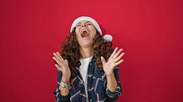 Латиноамериканка Средних Лет Удивляет Выражение Лица Рождественской Шляпе Изолированном Красном — стоковое фото