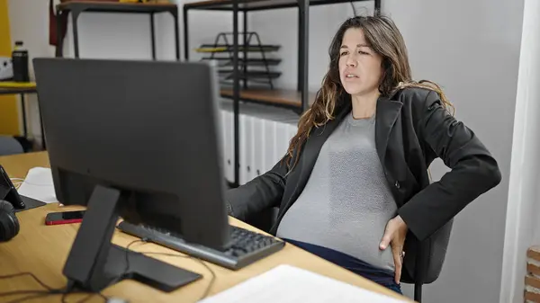 年轻的怀孕女工在办公室用电脑忍受背痛 — 图库照片