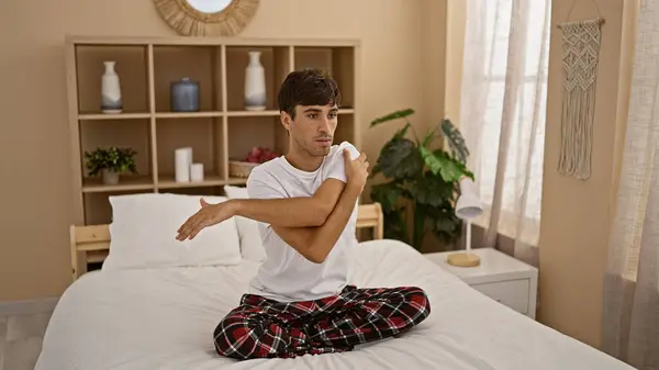 Красивий Молодий Іспаномовний Чоловік Насолоджується Спокійним Ранком Сидячи Ліжку Піжамах — стокове фото