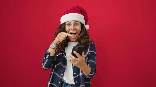 Moyen Age Femme Hispanique Portant Chapeau Noël Pointant Vers Smartphone — Photo