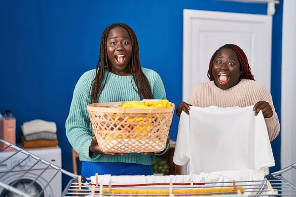 Dwie Afrykańskie Kobiety Wiszące Sznurze Ubrań Świętujące Szaleństwo Zdumione Sukcesem — Zdjęcie stockowe