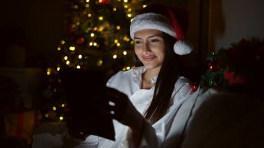 Genç, güzel, İspanyol bir kadın dokunmatik bir evde Noel 'i kutluyor.