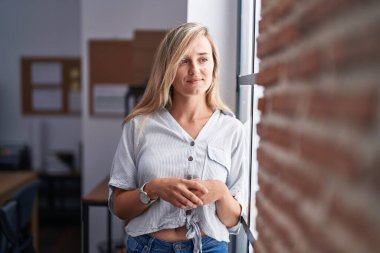 Ofiste kendine güvenen genç sarışın iş kadını gülümsemesi.