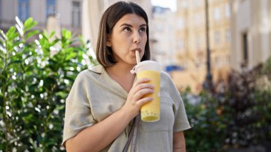 Genç ve güzel İspanyol kadın Viyana sokaklarında köpüklü çay içiyor.