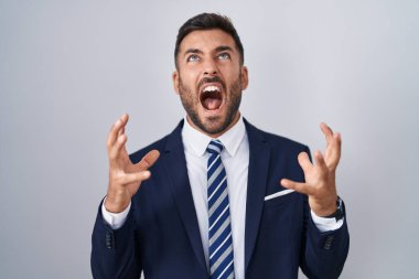 Yakışıklı, takım elbiseli, kravatlı deli deli deli bağrışan, agresif bir ifadeyle bağıran ve kollarını kaldıran bir İspanyol. hüsran kavramı. 