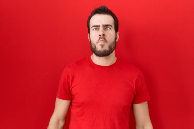 Gündelik kırmızı tişört giyen genç İspanyol adam dudaklarıyla balık suratı yapıyor, çılgınca ve komik bir jest. Komik ifade. 