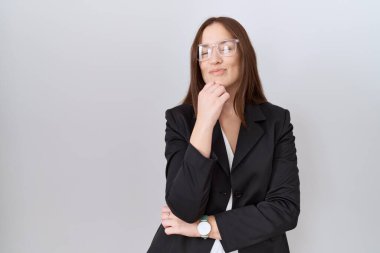 İş ceketi ve gözlük takan güzel esmer kadın kameraya kendinden emin bir şekilde bakıyor kollarını kavuşturup, çenesini kaldırarak gülümsüyor. Olumlu düşünmek. 