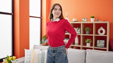 Genç İspanyol kadın evde kendine güvenerek gülümsüyor.