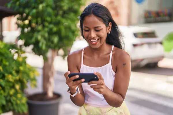 Young beautiful woman smiling confident watching video on smartphone at street