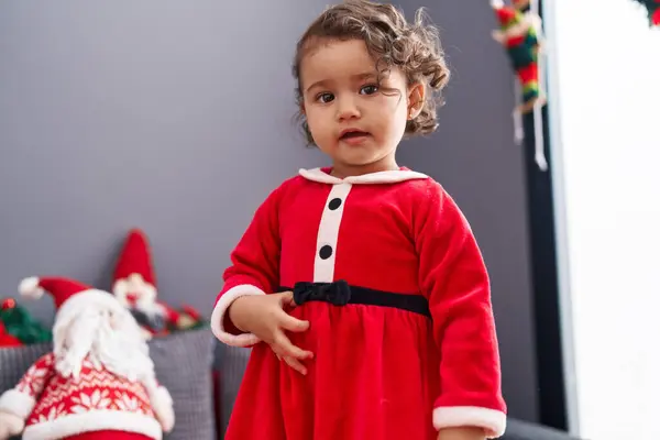 自宅でクリスマスの装飾でソファーに立って自信を持って微笑む愛らしいヒスパニックの幼児 — ストック写真