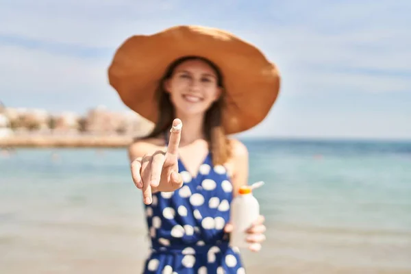 Молодая Блондинка Туристка Держит Бутылку Солнцезащитным Кремом Показывая Палец Лосьоном — стоковое фото