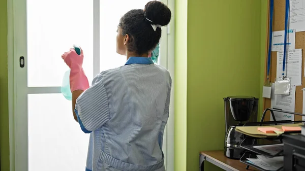 African american woman clean professional cleaning window at office