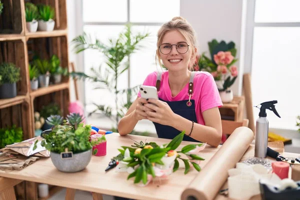 Joven Florista Rubia Sonriendo Confiada Usando Teléfono Inteligente Tienda Flores —  Fotos de Stock