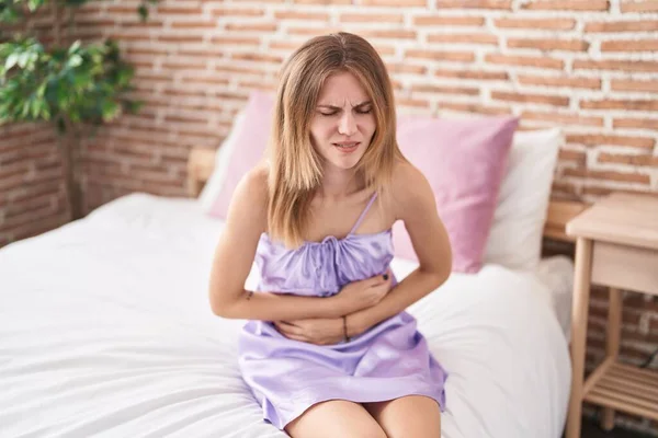 Jovem Loira Sofrendo Por Dor Menstrual Sentada Cama Quarto — Fotografia de Stock