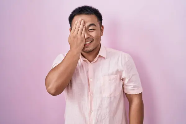 Čínský Mladý Muž Stojící Nad Růžovým Pozadím Zakrývající Jedno Oko — Stock fotografie