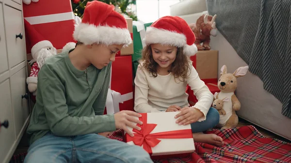 Δύο Παιδιά Ξεπακετάρει Δώρο Κάθεται Στο Πάτωμα Από Χριστουγεννιάτικο Δέντρο — Φωτογραφία Αρχείου
