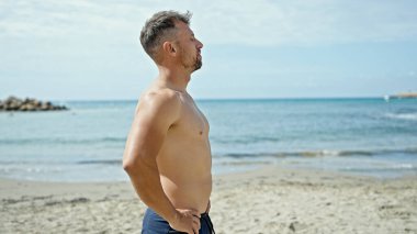 Kumsalda nefes alan genç adam.