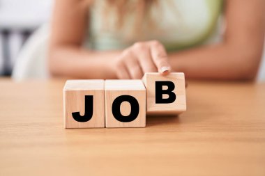 Masada iş sözcüğü olan küpleri tutan genç bir kadın.