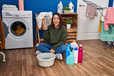 Genç İspanyol kadın çamaşırları elleriyle yıkıyor ve başarılı bir fikirle işaret ediyor. Heyecanlı ve mutlu. Bir numara.. 