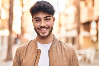 Sokakta kendinden emin gülümseyen İspanyol genç adam.