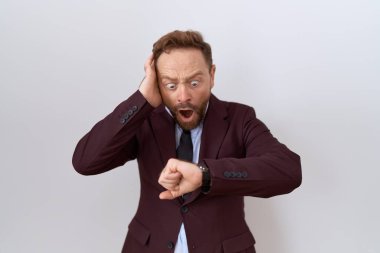 Orta yaşlı iş adamı, sakallı, kravatlı, takım elbiseli, saati seyreden, geç kalmaktan korkan. 