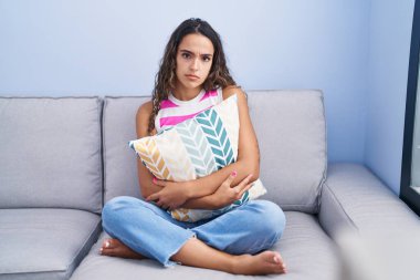 Genç İspanyol kadın evdeki kanepede oturuyor. Bilinci kapalı ve kafası karışık. şüphe kavramı. 