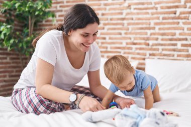 Anne ve oğlu yatak odasında oynuyorlar.