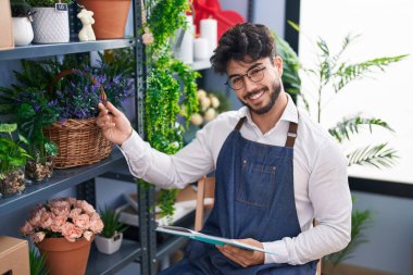 Çiçekçide deftere yazan İspanyol bir çiçekçi.