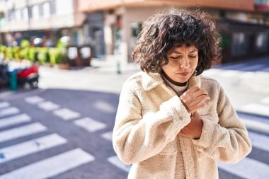 Young beautiful hispanic woman coughing at street