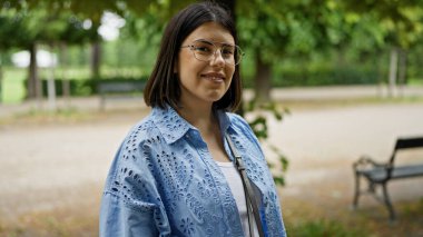 Viyana 'da parkta kendinden emin gülümseyen güzel İspanyol kadın.