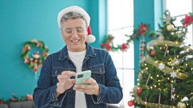 Kafkasyalı genç adam akıllı telefon kullanarak Noel 'i evde kutluyor