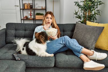 Beyaz bir kadın evde köpekle birlikte kanepede oturup film izlerken şaşırdı.