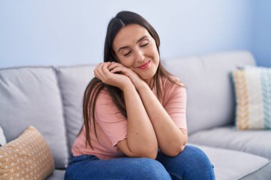 Evdeki kanepede oturan kendine güvenen güzel İspanyol kadın.