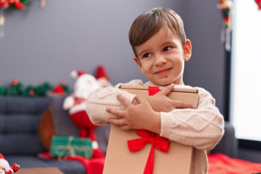 Sevimli İspanyol çocuk Noel hediyesini kucaklıyor.