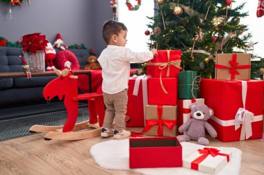 Evde Noel ağacı süsleyen sevimli İspanyol çocuk.