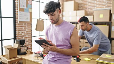 Ofiste çalışan iki işçi touchpad kullanıyor.