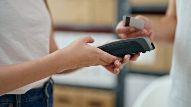 Ecommerce 'de çalışan genç kadın ve erkek kredi kartıyla ödeme yapıyorlar.