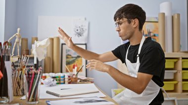 Resim dersinden kaçan, resim stüdyosundaki buruşuk kağıtları fırlatan genç İspanyol ressam.